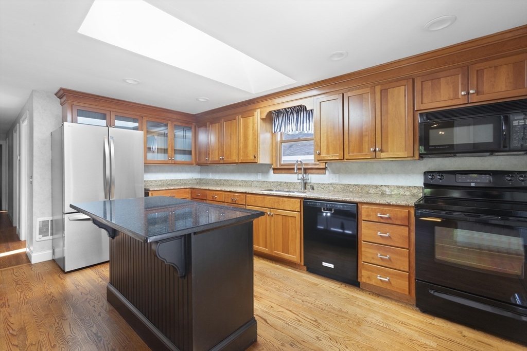 152 Coburn Road Berlin, MA 01503 - Photo 12 of 40 a kitchen with stainless steel appliances granite countertop a stove a sink dishwasher a refrigerator and a microwave oven with wooden floor