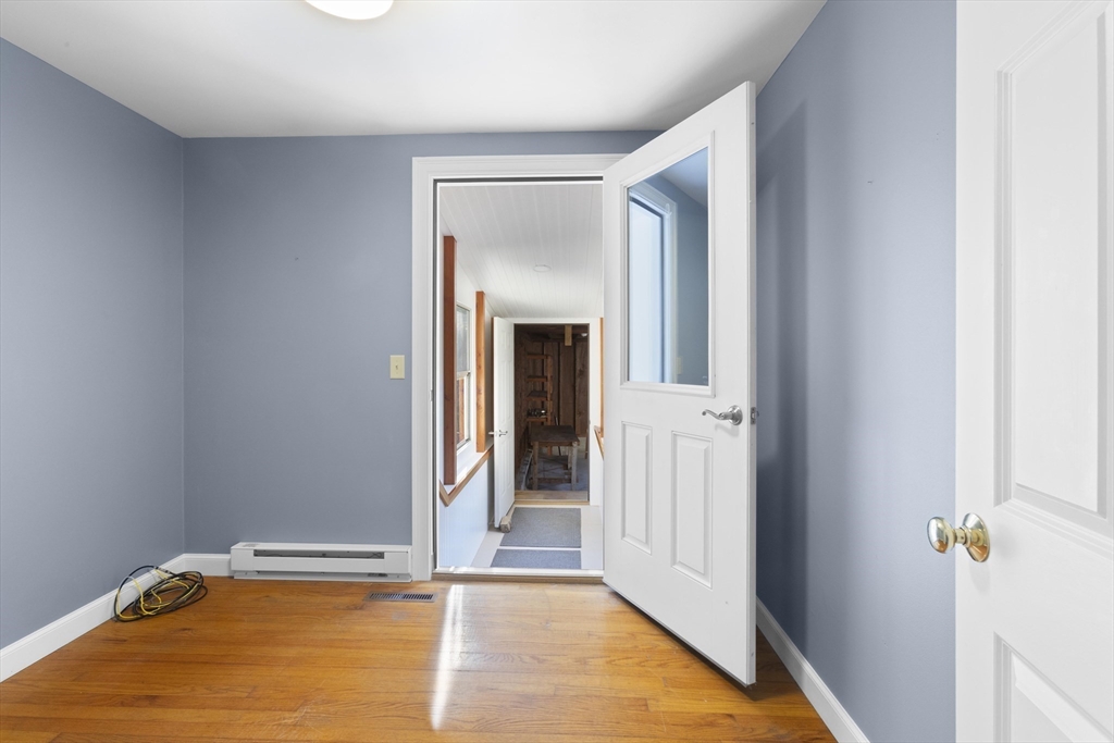 152 Coburn Road Berlin, MA 01503 - Photo 32 of 40 a view of a livingroom with wooden floor and a ceiling fan