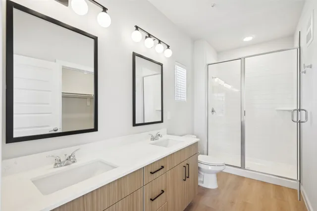 a bathroom with a double vanity sink mirror and toilet