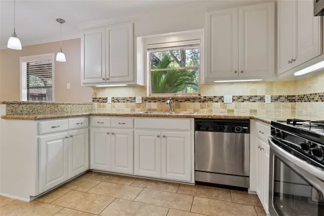 a kitchen with stainless steel appliances granite countertop a sink stove and cabinets