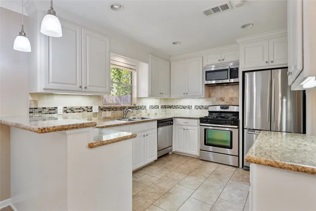 a kitchen with kitchen island granite countertop a stove sink and refrigerator