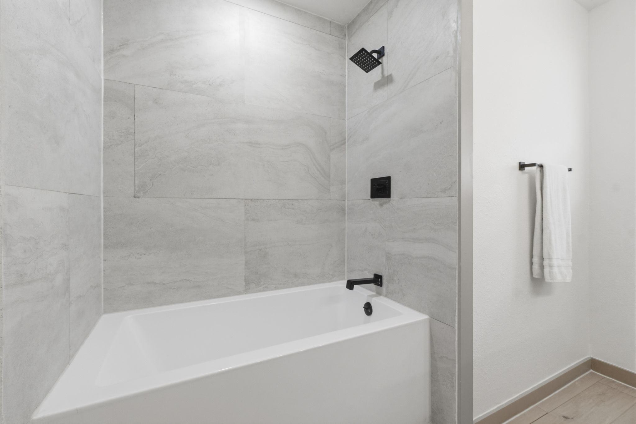 14850 Coaltown Road Willis, TX 77378 - Photo 18 of 41 Beautifully updated bathroom with oversized tile surround, modern black fixtures, and a spacious tub/shower combination.