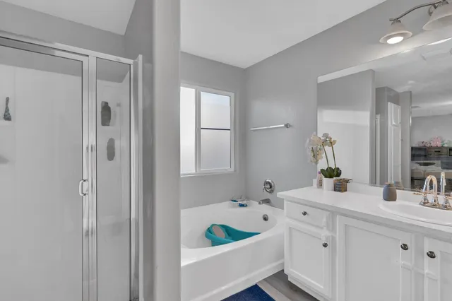 a bathroom with a tub a sink and a large mirror