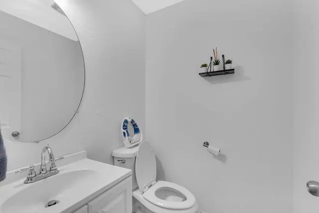 a bathroom with a sink vanity mirror and toilet