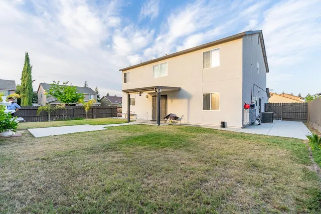 a view of a house with backyard and sitting area