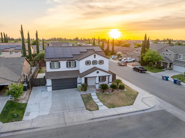 an aerial view of a house with a yard and lake view