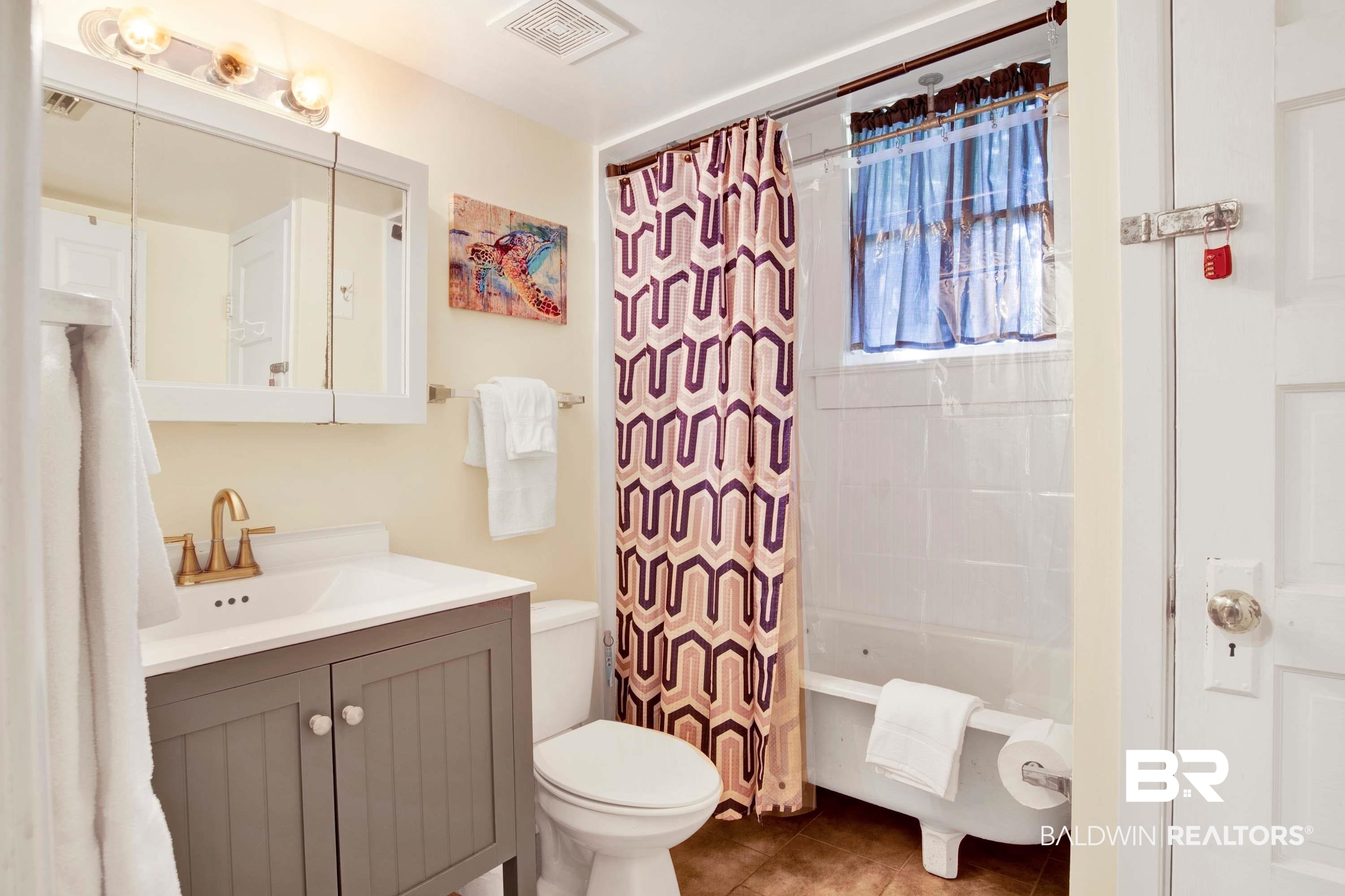 1141 Montauk Avenue Mobile, AL 36604 - Photo 15 of 15 Full bath with visible vents, toilet, tile patterned floors, vanity, and shower / bathtub combination with curtain