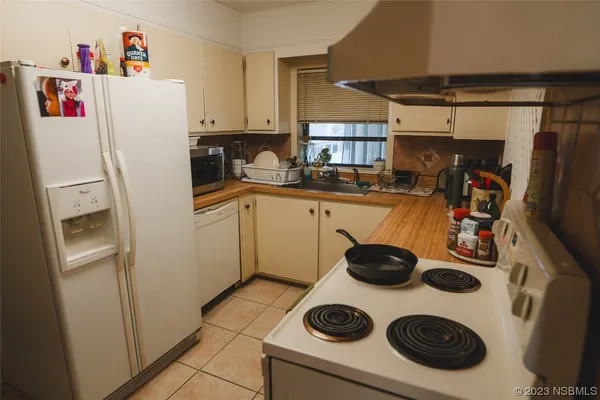a kitchen with a sink a refrigerator and cabinets