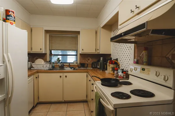 a kitchen with a refrigerator and a stove top oven