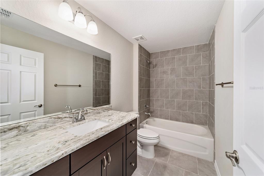 7866 North Manville Road Citrus Springs, FL 34434 - Photo 11 of 19 a bathroom with a granite countertop sink a toilet and bathtub