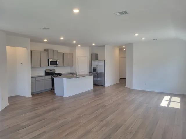 a large kitchen with stainless steel appliances granite countertop a large counter top a sink and a stove