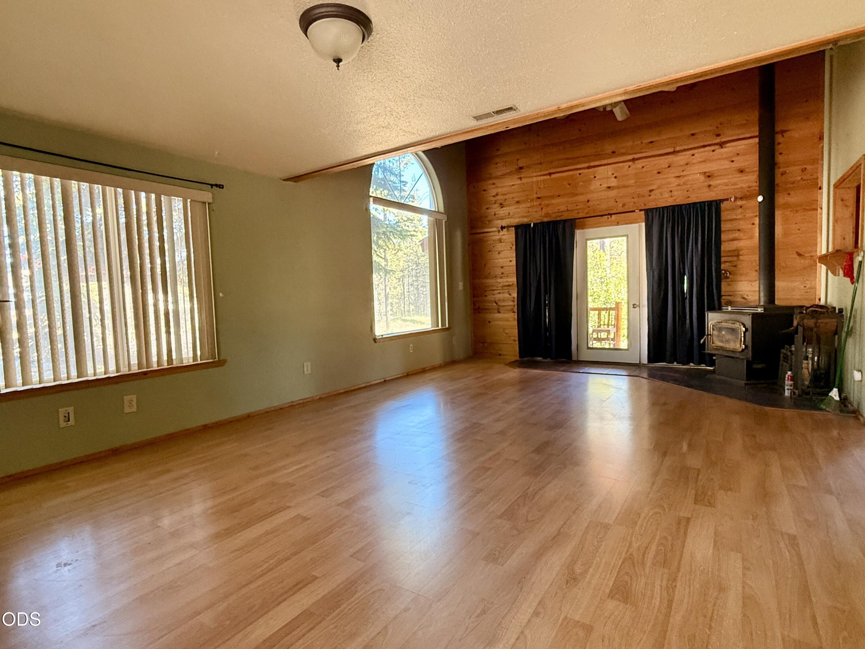 16025 Strawn Road La Pine, OR 97739 - Photo 6 of 95 a view of an empty room with wooden floor and a window