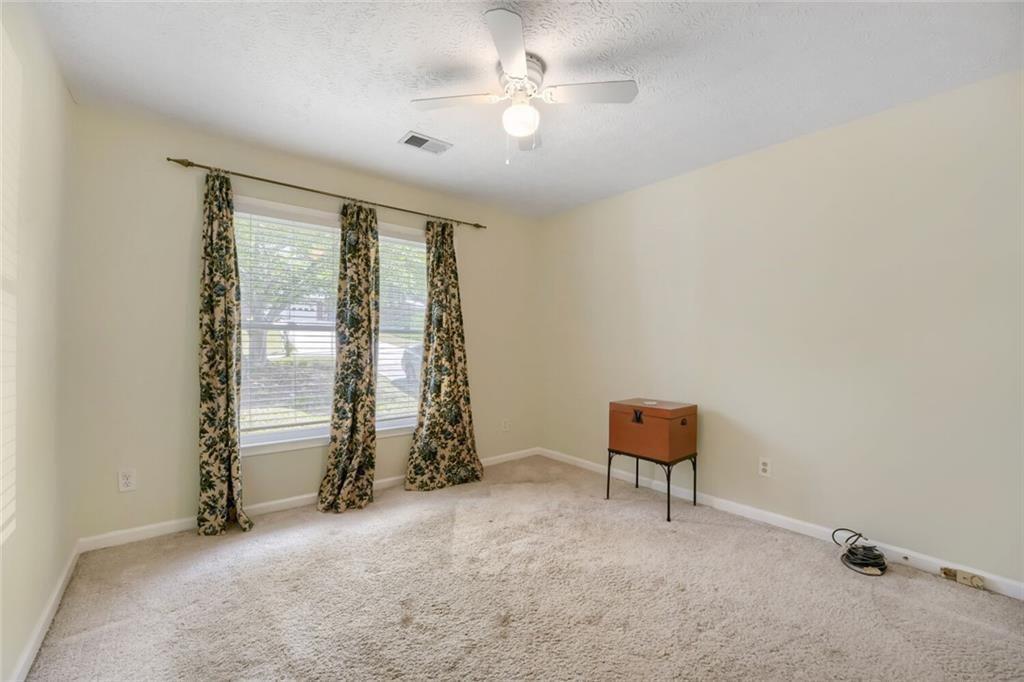2128 Cluster Lane Grayson, GA 30017 - Photo 17 of 40 an empty room with windows and ceiling fan
