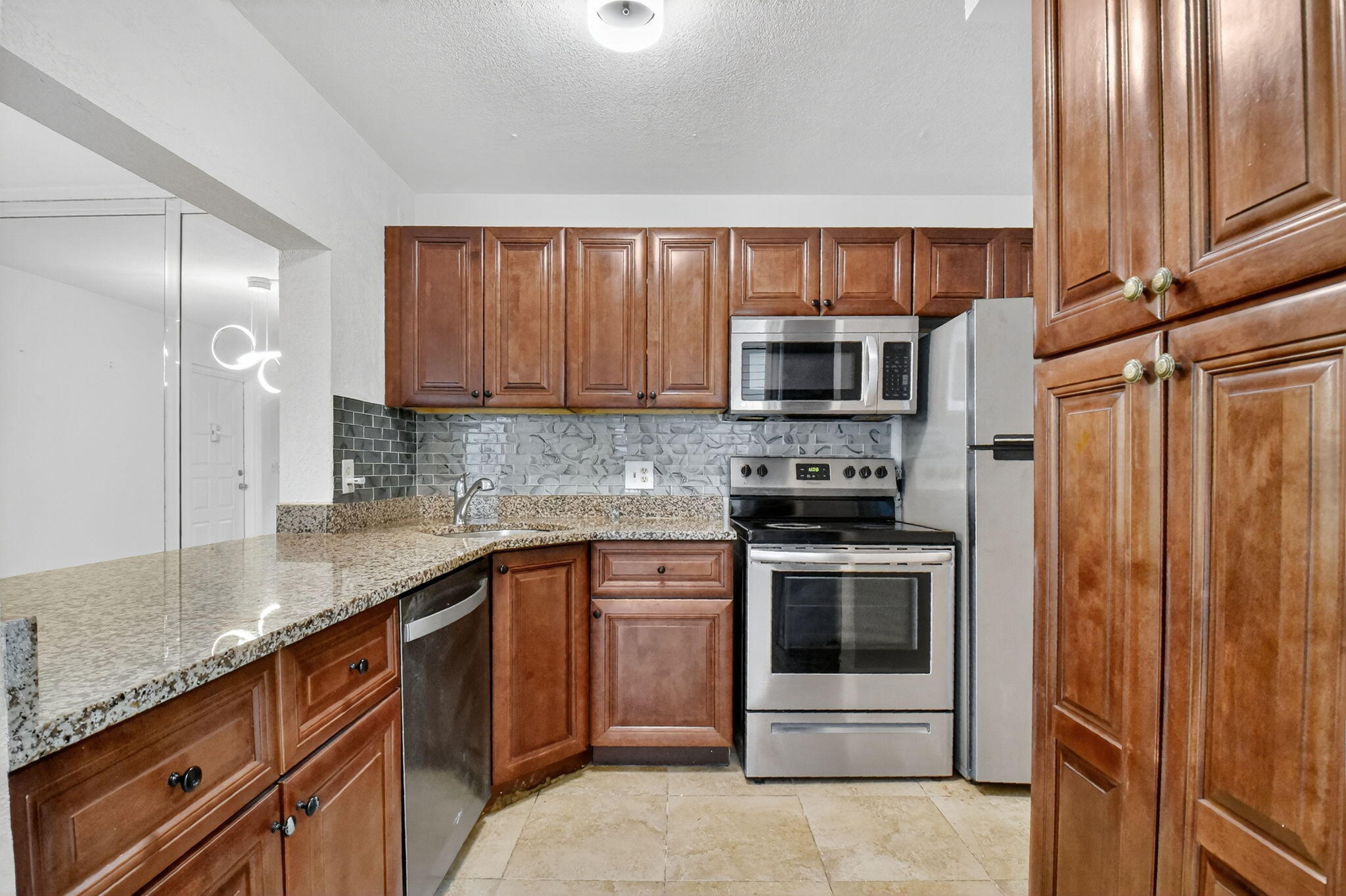 208 Foxtail Drive, Unit B2 Greenacres, FL 33415 - Photo 12 of 33 a kitchen with stainless steel appliances granite countertop a stove a sink and a microwave