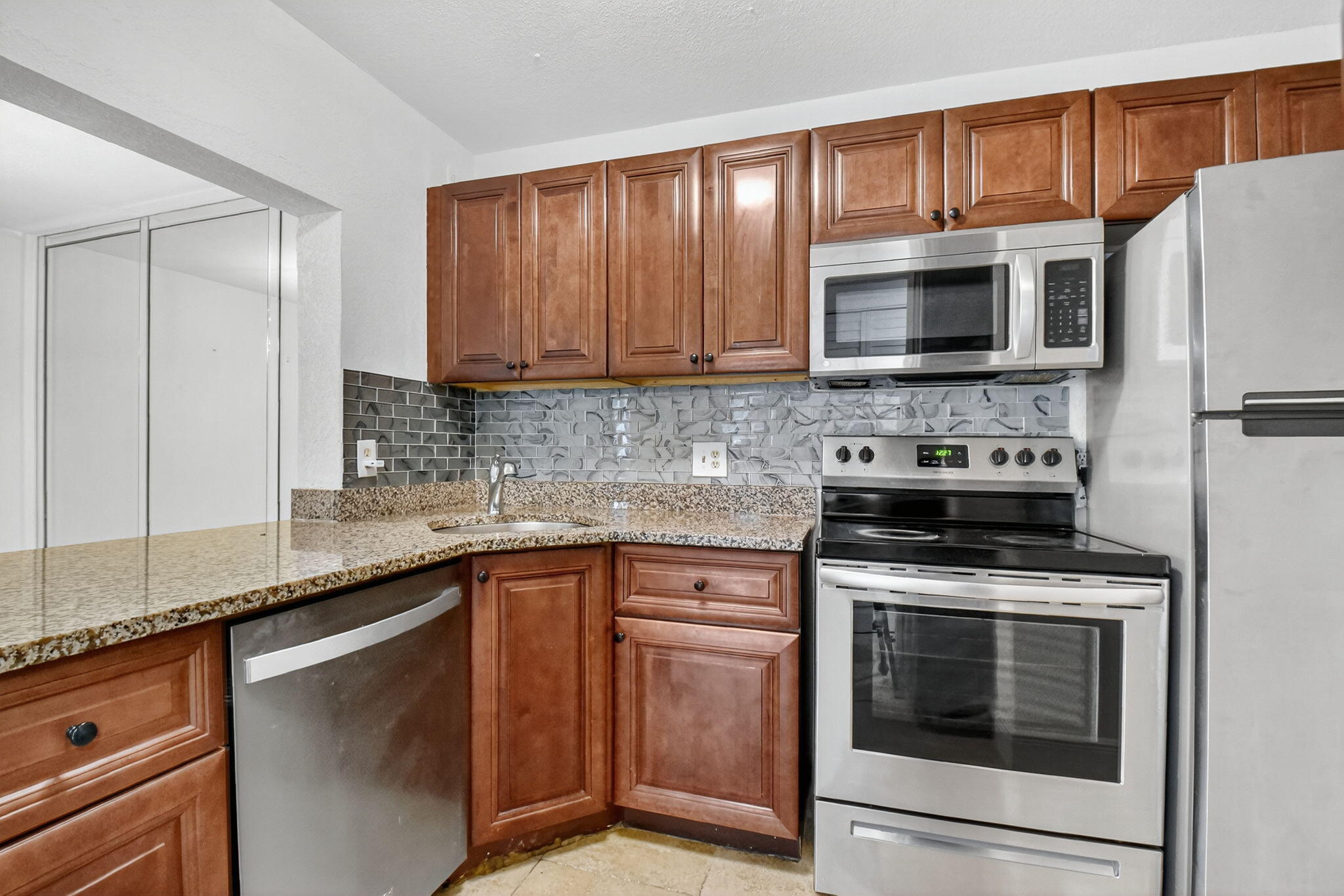 208 Foxtail Drive, Unit B2 Greenacres, FL 33415 - Photo 13 of 33 a kitchen with cabinets stainless steel appliances a sink and a counter space