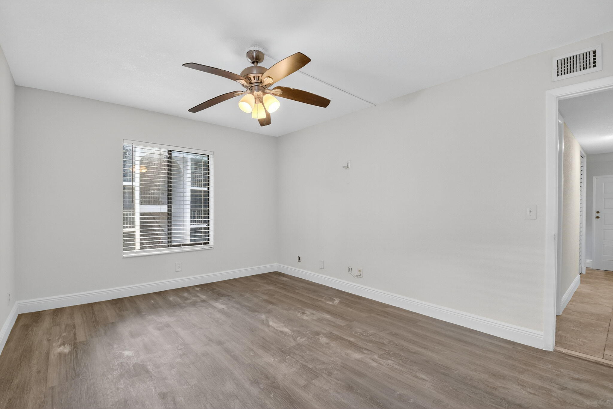 208 Foxtail Drive, Unit B2 Greenacres, FL 33415 - Photo 22 of 33 a view of an empty room with wooden floor and a window