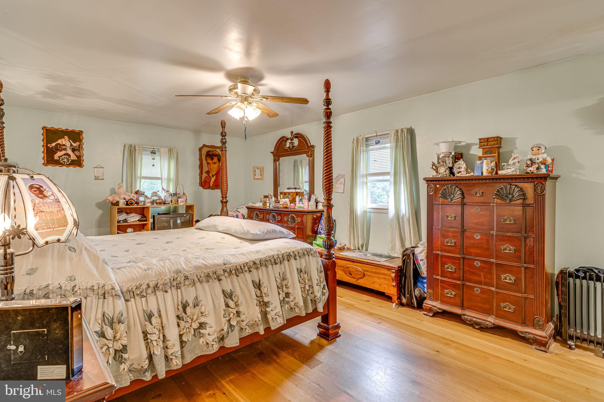 5865 Mackall Road St. Leonard, MD 20685 - Photo 10 of 24 a spacious bedroom with a bed and wooden floor