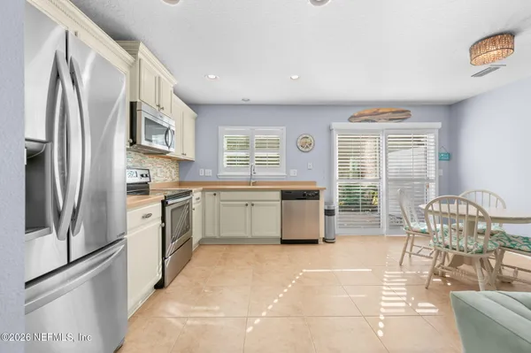 a kitchen with granite countertop a sink a stove and cabinets