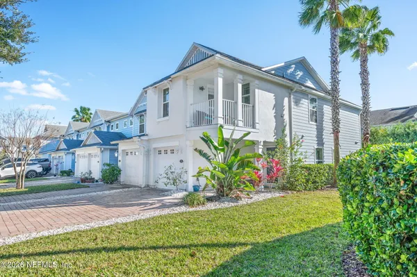 a front view of a house with a yard and potted plants