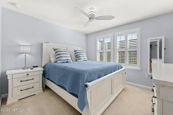 a spacious bedroom with a large bed and a chandelier