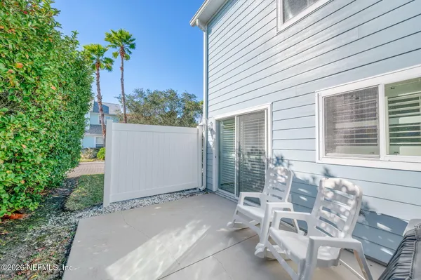 a view of a palm plant from a blue house with pool
