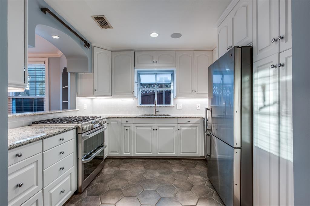 818 Valencia Street Dallas, TX 75223 - Photo 19 of 38 a kitchen with granite countertop stainless steel appliances a sink stove and refrigerator
