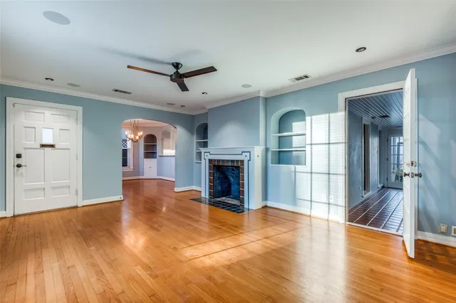 a view of empty room with wooden floor and fireplace