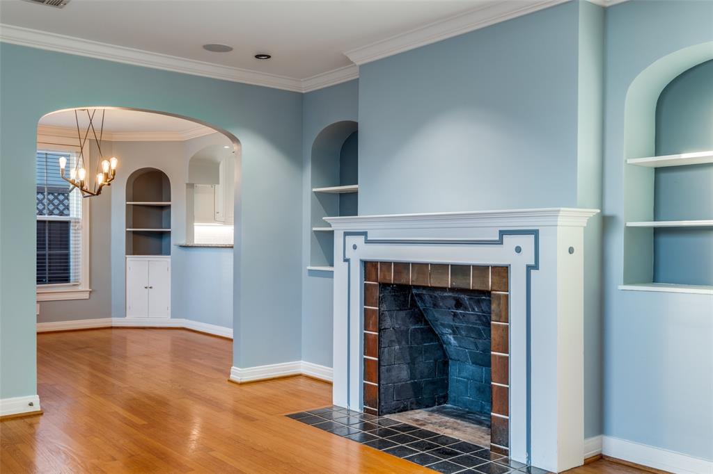 818 Valencia Street Dallas, TX 75223 - Photo 9 of 38 a view of an empty room with wooden floor fireplace and a window