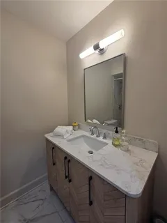 a bathroom with a granite countertop sink and a mirror