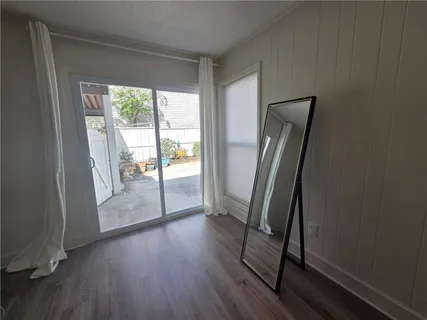 a view of a hallway with wooden floor and glass door