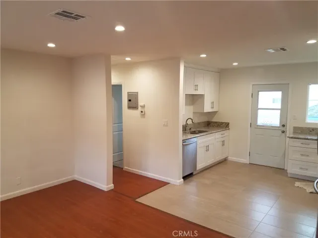 a kitchen with a refrigerator and white cabinets