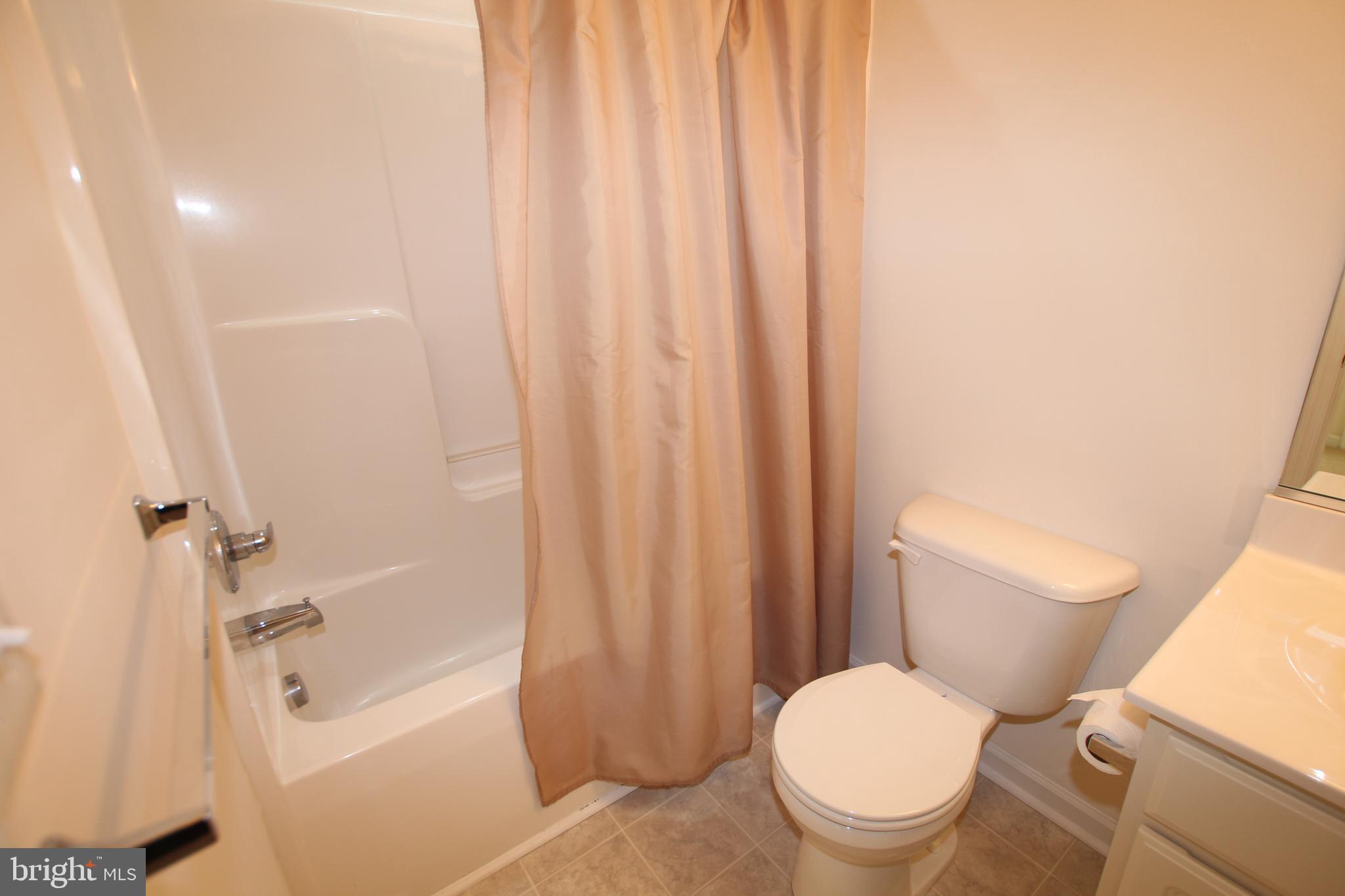 35385 Winthrop Court, Unit B162 Millsboro, DE 19966 - Photo 17 of 18 a white toilet sitting next to a bath tub