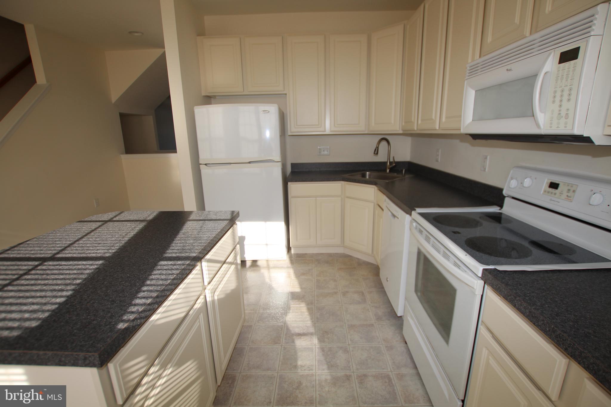 35385 Winthrop Court, Unit B162 Millsboro, DE 19966 - Photo 7 of 18 a kitchen that has a sink and a stove
