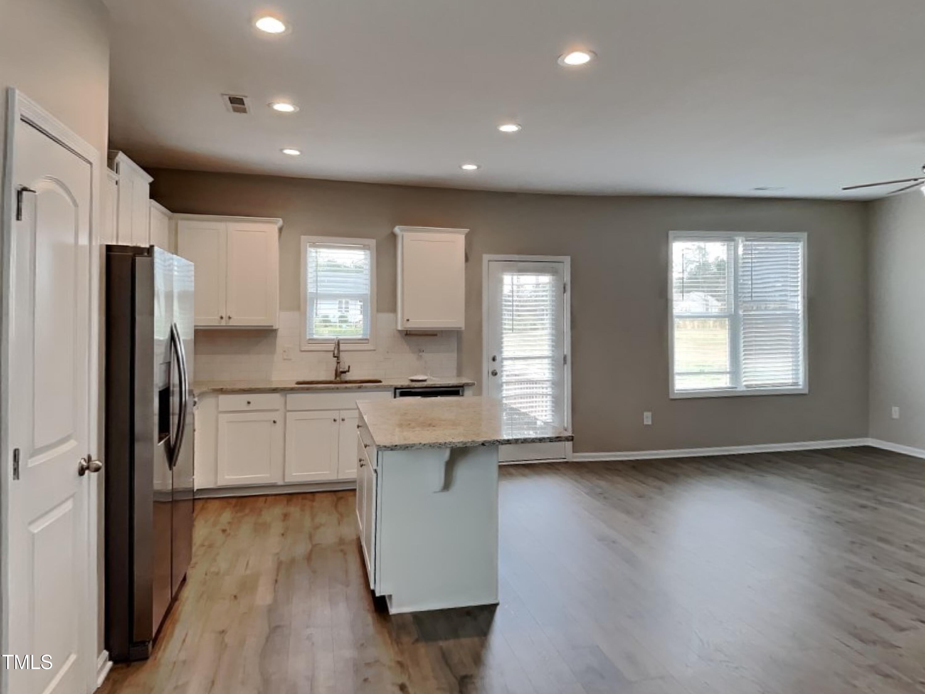 376 Olde Place Drive Zebulon, NC 27597 - Photo 6 of 16 a kitchen with stainless steel appliances granite countertop a refrigerator a sink dishwasher a stove and white countertops with wooden floor