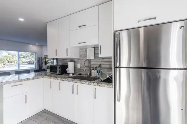 a kitchen with stainless steel appliances granite countertop a refrigerator and a sink