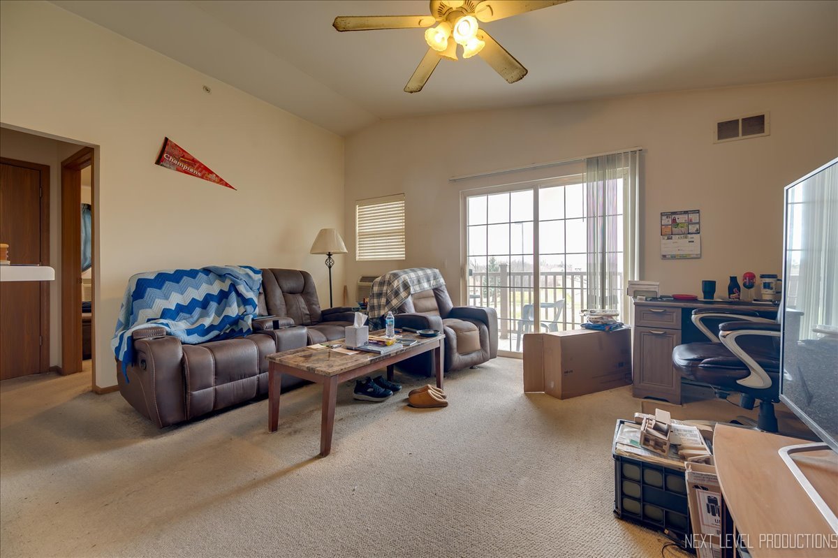 1506 Spring Brook Court, Unit 2A Round Lake Beach, IL 60073 - Photo 11 of 13 a living room with furniture a flat screen tv and a large window