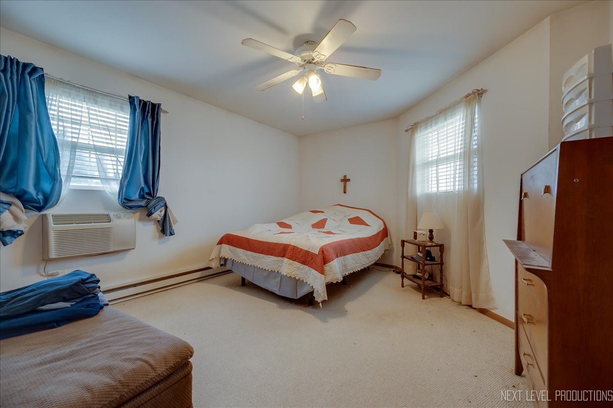 1506 Spring Brook Court, Unit 2A Round Lake Beach, IL 60073 - Photo 8 of 13 a bedroom with a bed and a refrigerator
