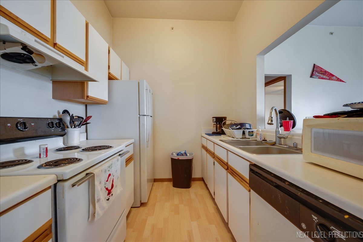 1506 Spring Brook Court, Unit 2A Round Lake Beach, IL 60073 - Photo 10 of 13 a kitchen with a sink stove and cabinets