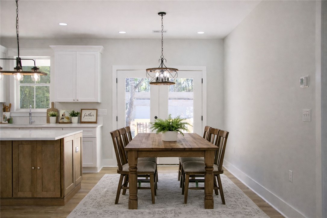 2515 Highway 29 Anderson, SC 29621 - Photo 12 of 38 An inviting dining area flows into a bright kitchen, illuminated by an elegant overhead fixture.