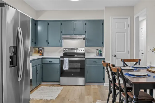 a kitchen with a stove a refrigerator and a stove top oven