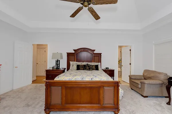 a bedroom with a bed and a mirror on the dresser