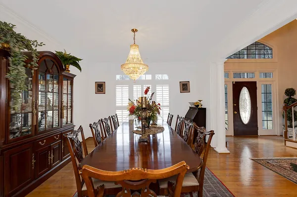 a view of a dining room with furniture a chandelier and wooden floor