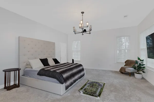 a bedroom with a bed and a chandelier