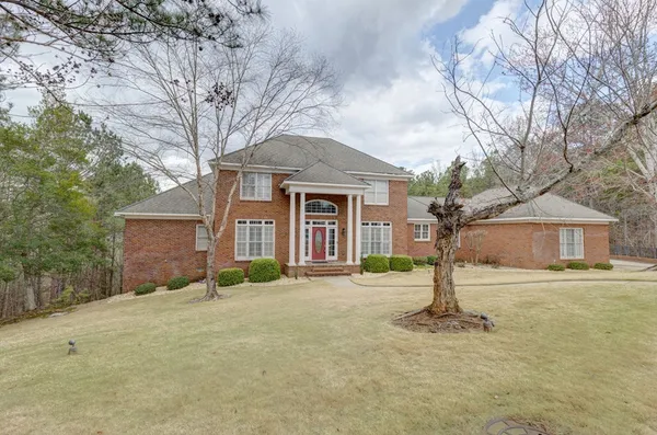 a front view of house with yard and trees around