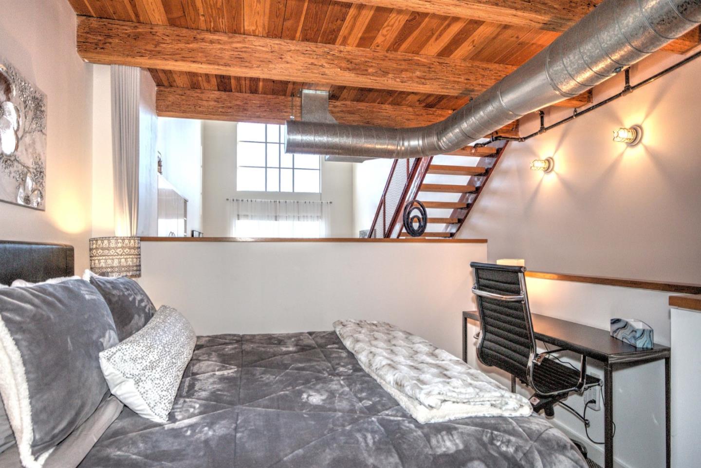 334 Santana Row, Unit 304 San Jose, CA 95128 - Photo 6 of 18 a bed sitting in a bedroom next to a window