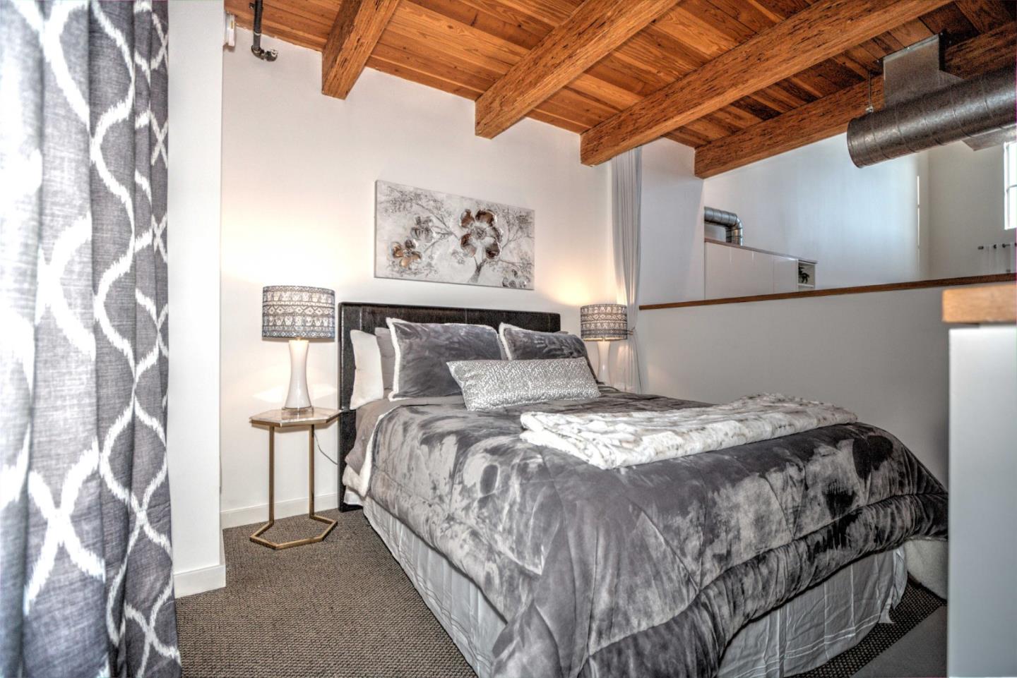 334 Santana Row, Unit 304 San Jose, CA 95128 - Photo 7 of 18 a bedroom with a bed and a painting on the wall