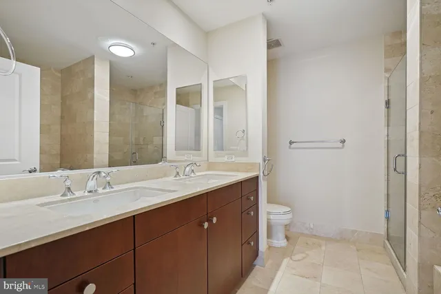 a bathroom with a double vanity sink toilet and a mirror