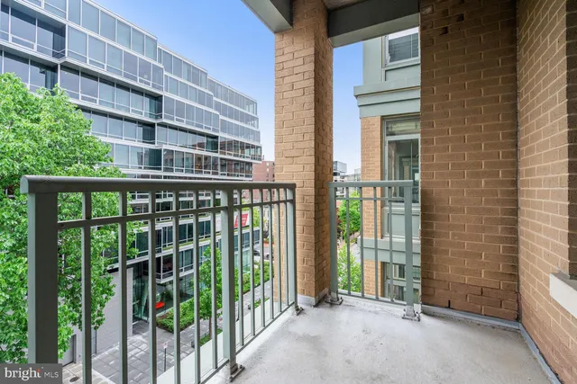 a view of a balcony with a floor to ceiling window and wooden fence