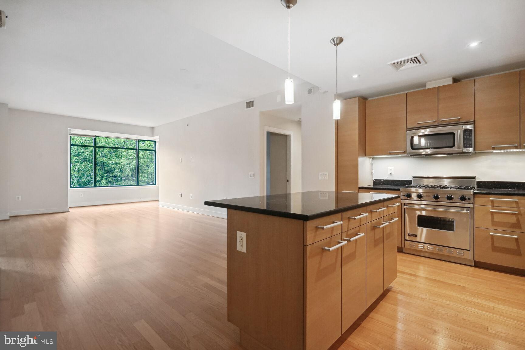 2425 L Street Northwest, Unit 637 Washington, DC 20037 - Photo 2 of 24 a kitchen with stainless steel appliances granite countertop a stove a sink and a refrigerator