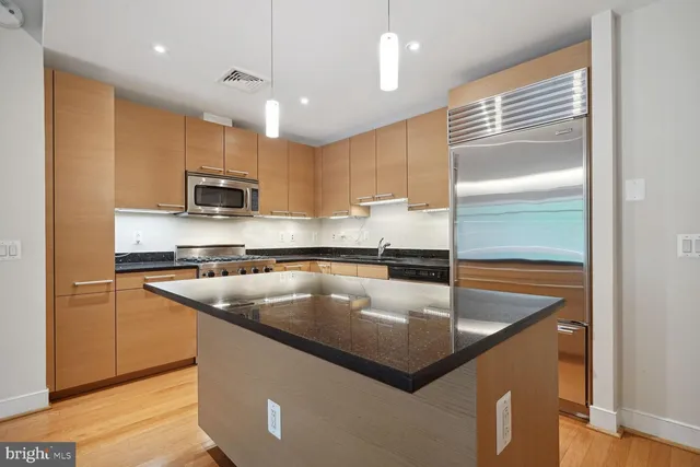 a kitchen with stainless steel appliances granite countertop a sink a stove and a refrigerator